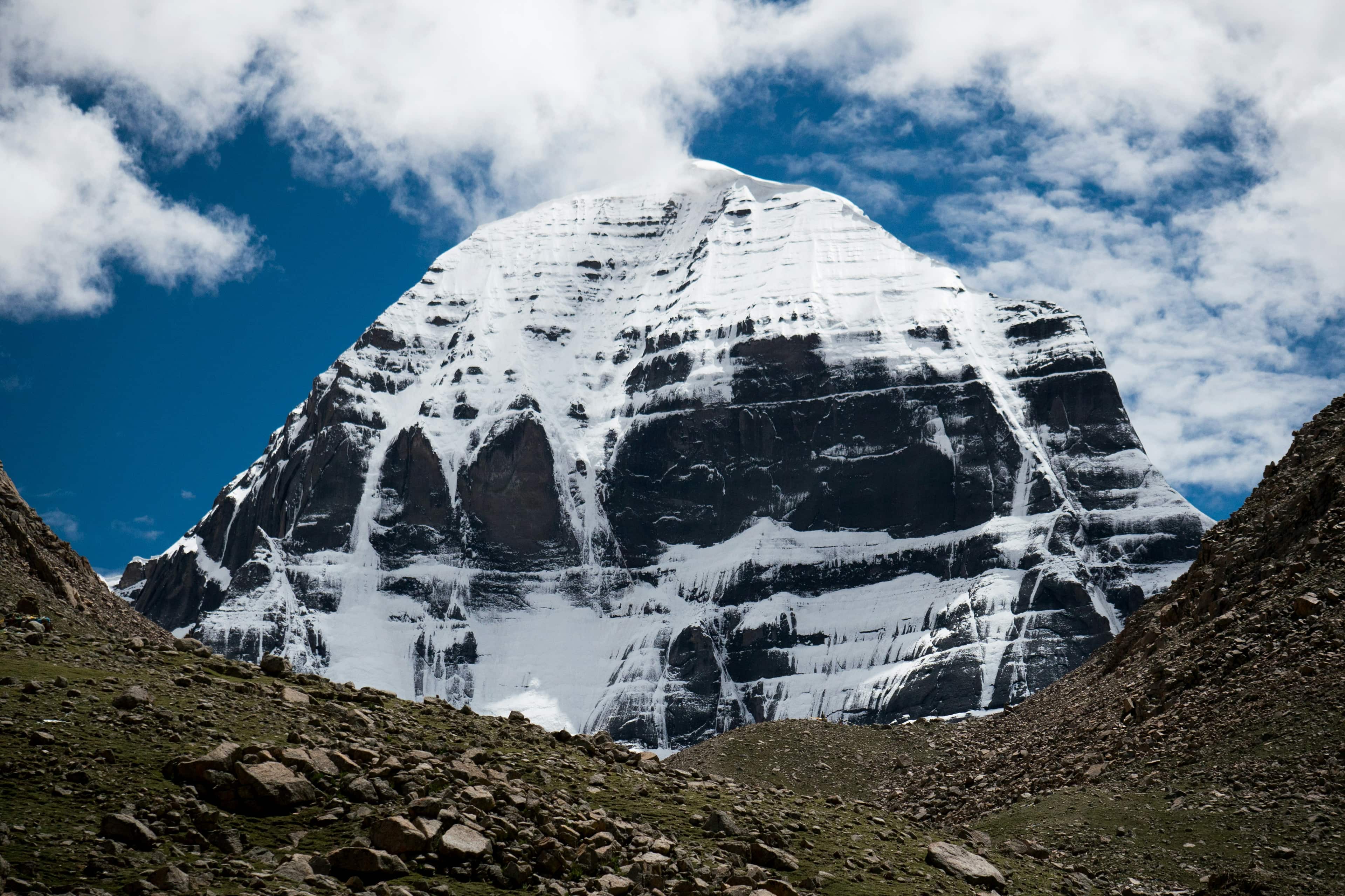 Snowbound mountain wall and blue sky near high-altitude route